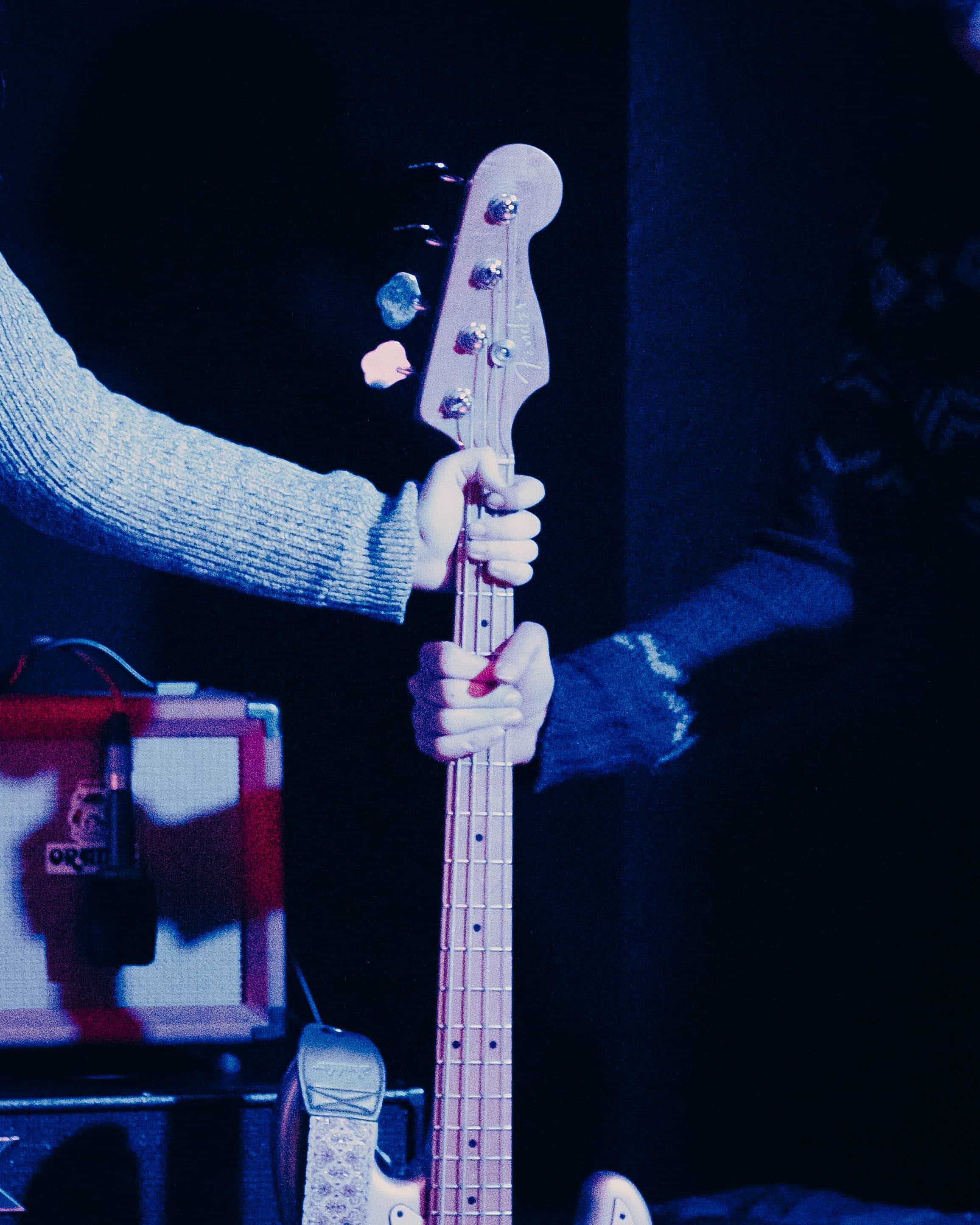 Due mani sul manico di un basso durante un concerto