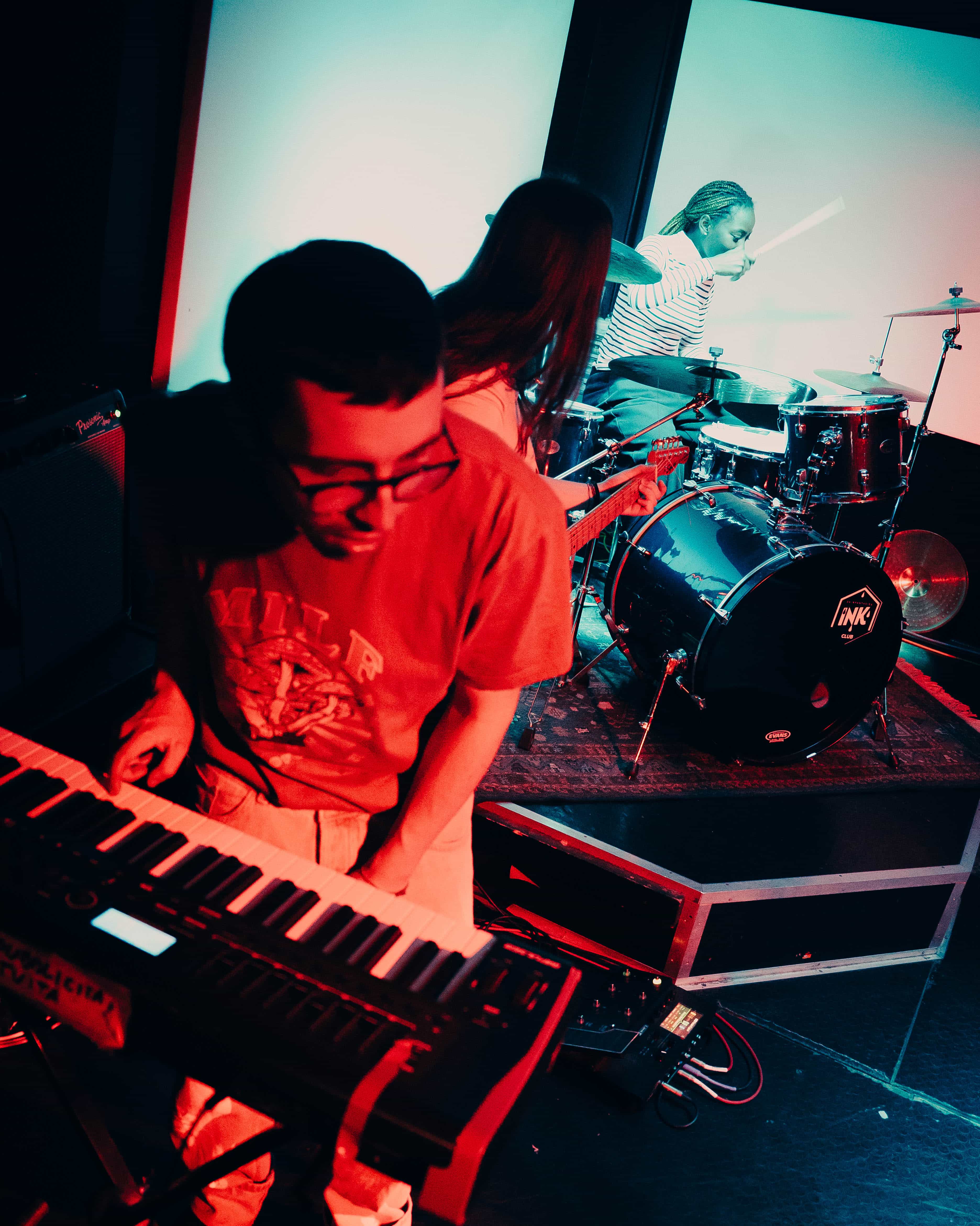 Tastiere in primo piano e batteria sul fondo durante una session